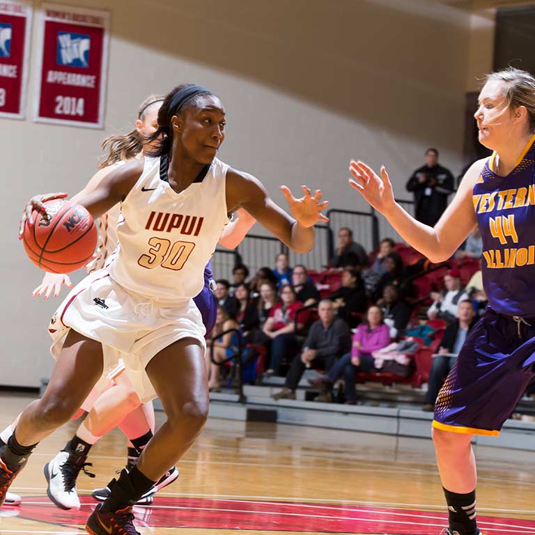 An IUPUI women's basketball player dribbles the ball during a game.