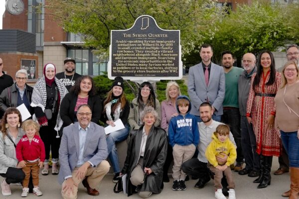 Arab Americans and friends stand in front of the Syrian Quarter Marker at Lucas Oil Stadium