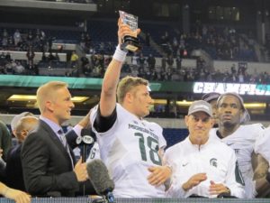 Michigan State quarterback Connor Cook holds the Grange-Griffin Championship Game MVP award before handing it to his offensive linemen.