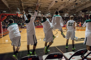 Forest Park High School players jumped off their sideline seats as their team scored on a 3-point shot during an Indiana High School Athletic Association sectional championship game in Huntingburg, Ind. (Photo by Michael E. Keating)